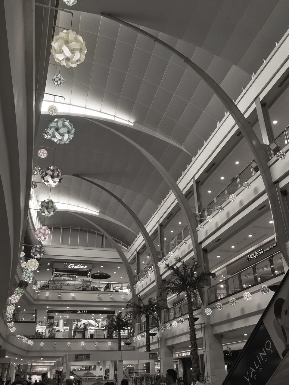 indoors, ceiling, architecture, built structure, illuminated, low angle view, shopping mall, incidental people, interior, lighting equipment, arch, modern, travel, transportation, large group of people, in a row, architectural column, railroad station, architectural feature, high angle view