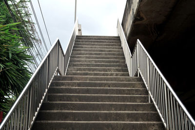 Low angle view of steps amidst buildings against sky