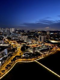 High angle view of illuminated city buildings against sky at night