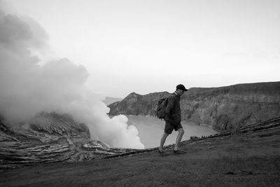 Side view of hiker walking by ijen volcano against clear sky