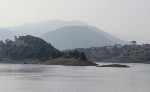 Scenic view of sea and mountains against sky