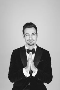 Portrait of young man standing against white background