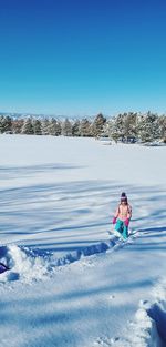 Children on snow against clear blue sky