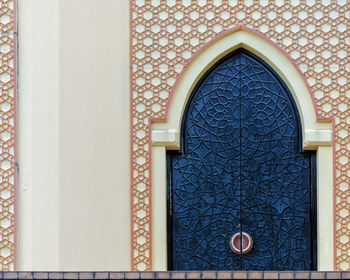 Traditional arabesque pattern on the wall, arched door with ornament, islamic architecture