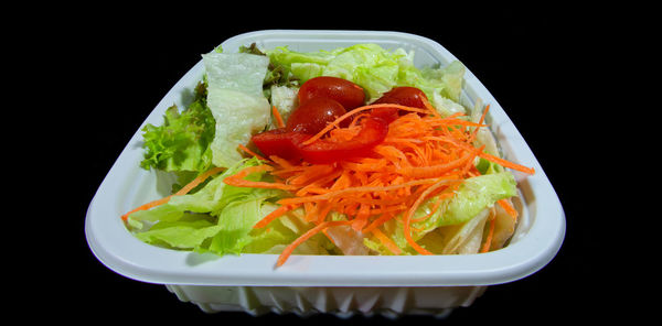 Close-up of salad served in plate against black background