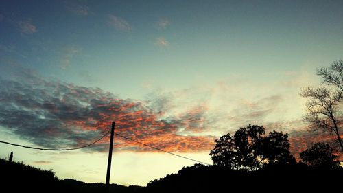 Silhouette of trees against cloudy sky