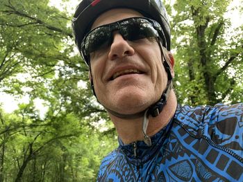 Low angle view of man wearing sunglasses against trees