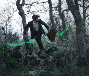 Full length of man standing by tree in forest