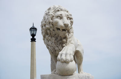 Low angle view of lion statue against sky