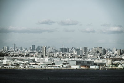 Buildings by sea against sky in city