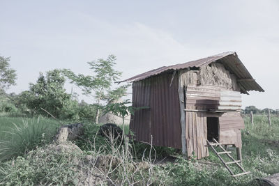 Abandoned house on field against sky
