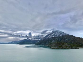 Scenic view of lake by mountains against sky