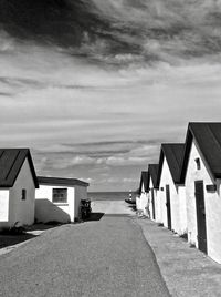 Houses on street amidst buildings against sky