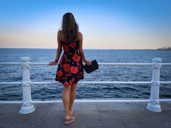 Rear view of woman wearing summer dress looking at the ocean