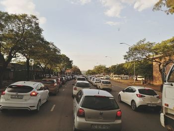 Traffic on road in city against sky