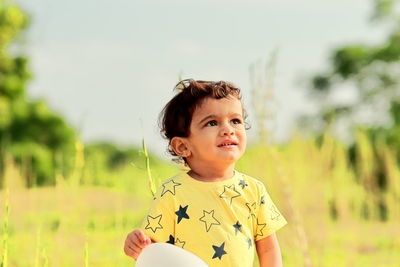 Portrait of cute girl standing on field
