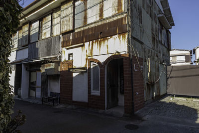 Abandoned building by street in city