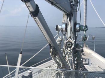 Close-up of sailboat sailing in sea against sky