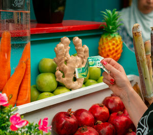 Midsection of woman holding fruits in container