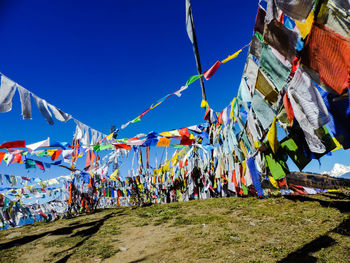 Low angle view of colorful flags hanging against sky