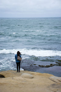 Rear view of man standing on beach