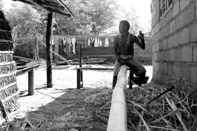 Man polishing bamboo while sitting on bench