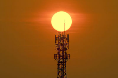 Low angle view of communications tower against sky during sunset