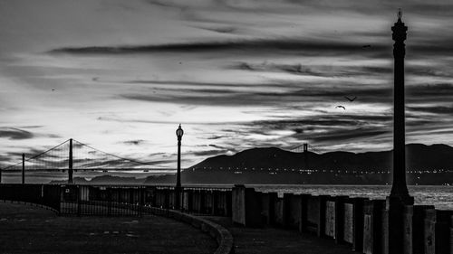 Street by sea against sky at dusk