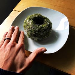 Cropped image of person by food in plate