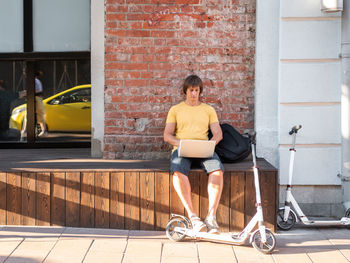 Man with laptop in street cafe. freelancer at work. student learns remotely. open air workplace.