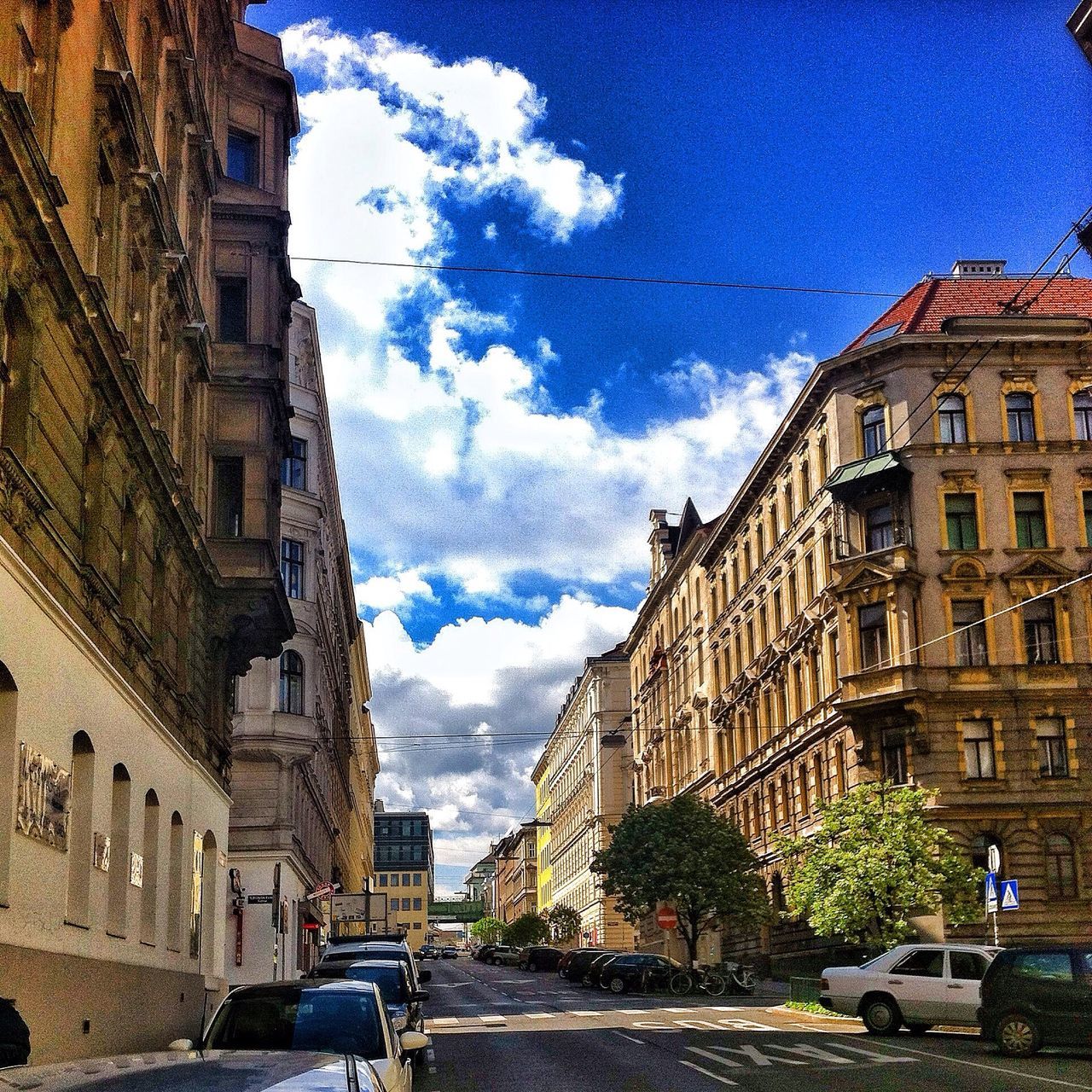 building exterior, architecture, built structure, transportation, street, car, land vehicle, sky, mode of transport, city, residential building, building, road, residential structure, city street, the way forward, city life, incidental people, cloud - sky, cloud