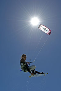 Low angle view of person paragliding against clear sky