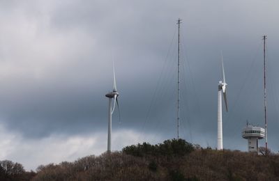 Windmill against cloudy sky