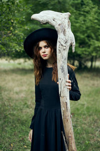 Portrait of young woman standing on field