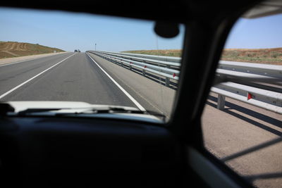 Car moving on road seen through windshield