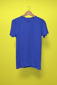 Blue umbrella hanging against yellow wall