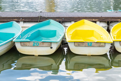 Blue and yellow boats float on the water next to the pier. boat station on beach. water transport