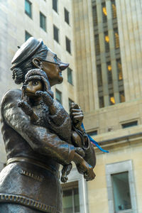 Low angle view of statue against building in city