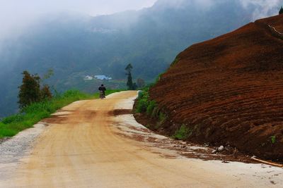 Road by mountain against sky