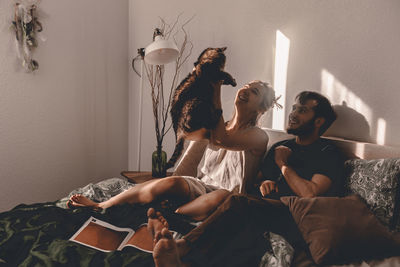 Couple playing with cat while sitting at home