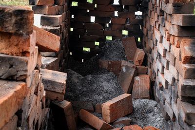 Stack of logs against trees