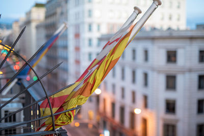 Low angle view of flags hanging on buildings in city