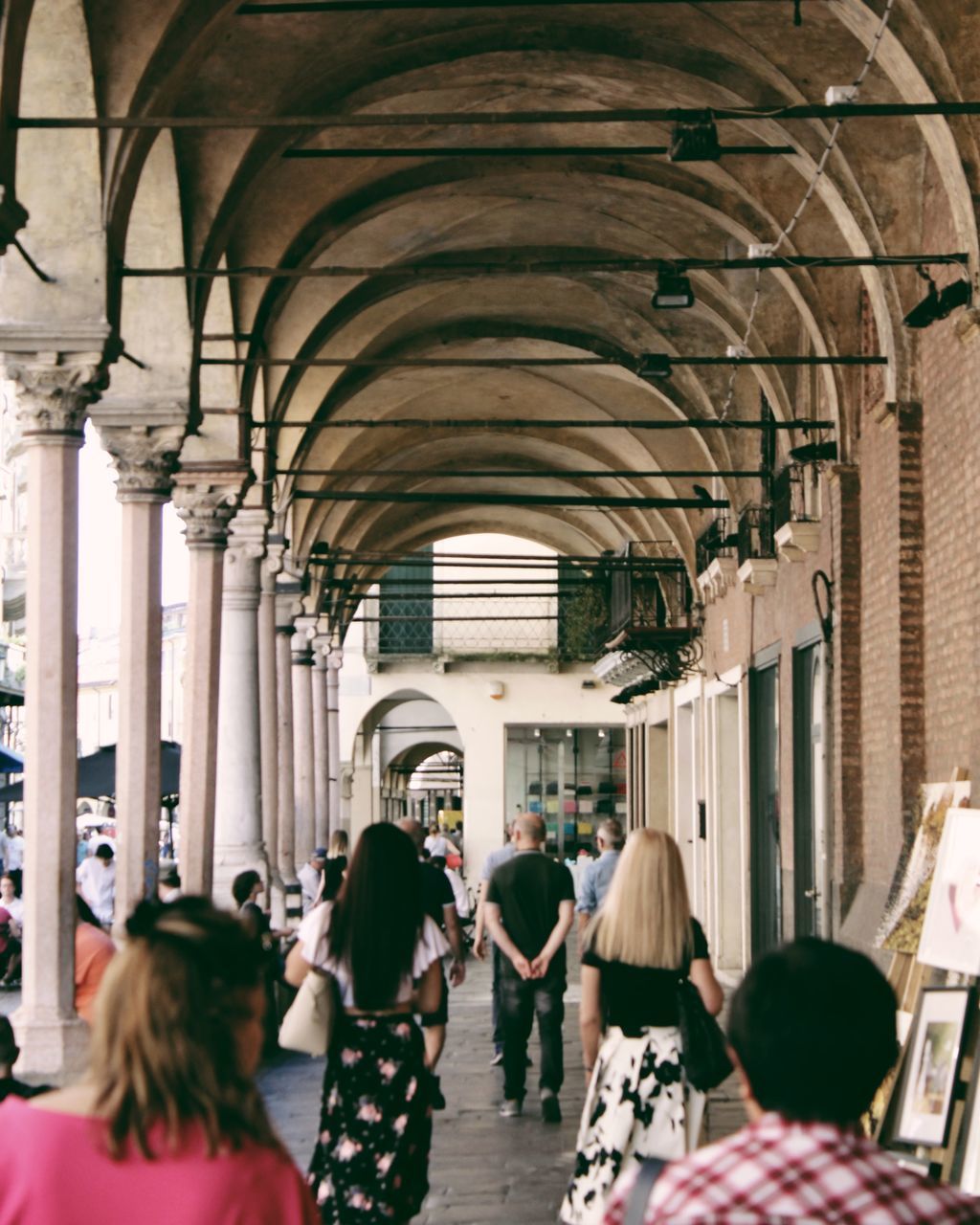REAR VIEW OF PEOPLE WALKING IN BUILDING
