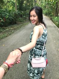 Young woman smiling while holding umbrella