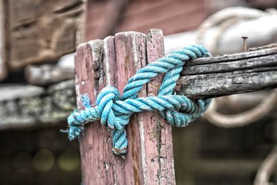 Close-up of rope tied on weathered wood