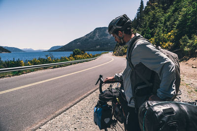 Side view of man riding motorcycle on road