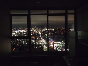 Illuminated buildings seen through window at night