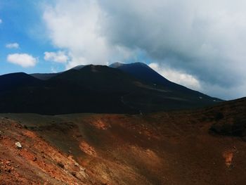 Scenic view of mountains against cloudy sky