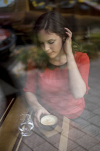 Close-up of woman holding coffee cup at table