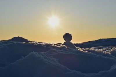 Silhouette of snow against sky during sunset